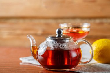 Bir çaydanlık dolusu sıcak çay peçetenin üzerinde masanın üzerinde. Yatay fotoğraf