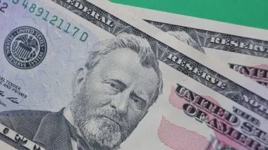 Yüz elli dolarlık büyük banknotlar yeşil arka planda katlanır.