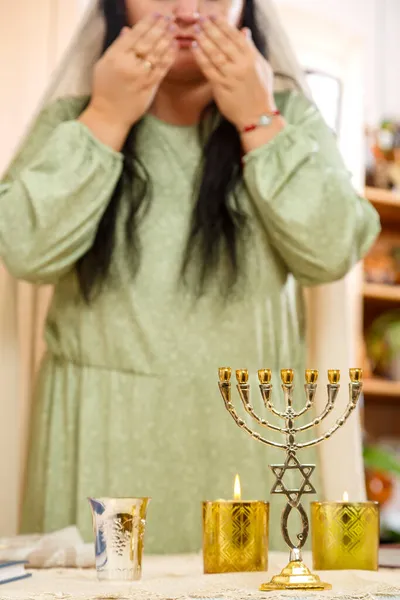 一个没有脸的犹太女人在安息日的蜡烛上读着祝福. — 图库照片