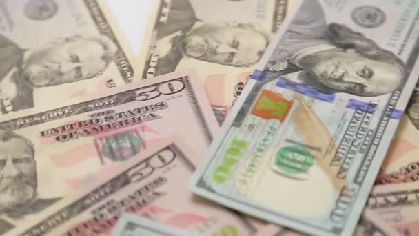 Velké dolarové bankovky jsou roztroušeny v nepořádku a točí se v kruhu — Stock video