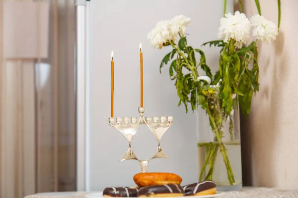 Lit Chanukiah com uma vela e shamash no primeiro dia de Chanukah na mesa festiva. Fotos De Bancos De Imagens Sem Royalties