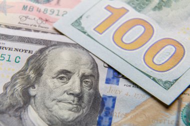 Masaya dağılmış yüz dolarlık banknotların yakın plan çekimi..