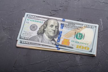 Gri arka planda 100 dolarlık banknotlar..