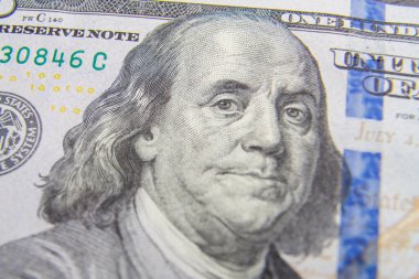 One hundred dollar bills fragments on a flat surface large.