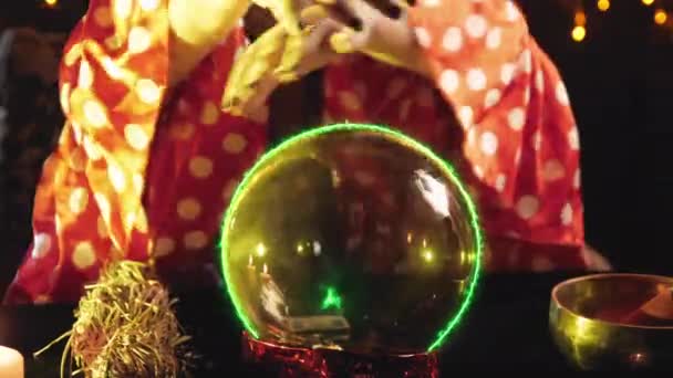 A young brunette fortune teller reads the future on a crystal ball in the salon — Stock Video