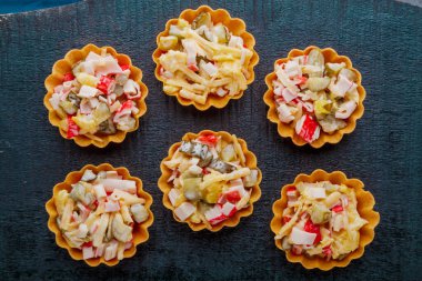 Siyah arka planda tartlı yengeç salatası..