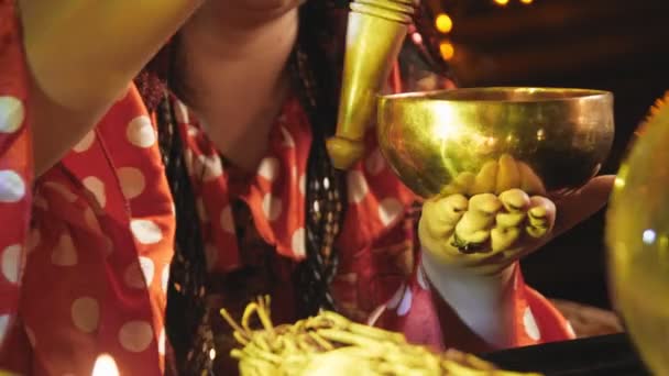 A woman works with a singing bowl by candlelight — Stock videók