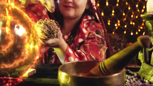 Eine junge Zauberin zaubert, liest eine Handlung im Gras bei Kerzenschein — Stockvideo