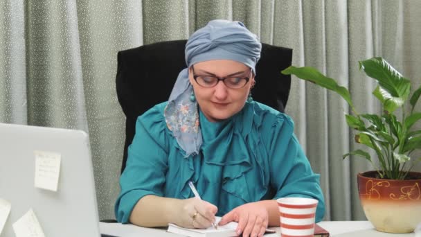 Juutalainen nainen perinteisessä päähineessä työskentelee kotitoimistossa kannettavan tietokoneen kanssa. — kuvapankkivideo
