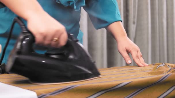 Γυναίκα σιδέρωμα ρούχα στην σιδερώστρα στο δωμάτιο — Αρχείο Βίντεο