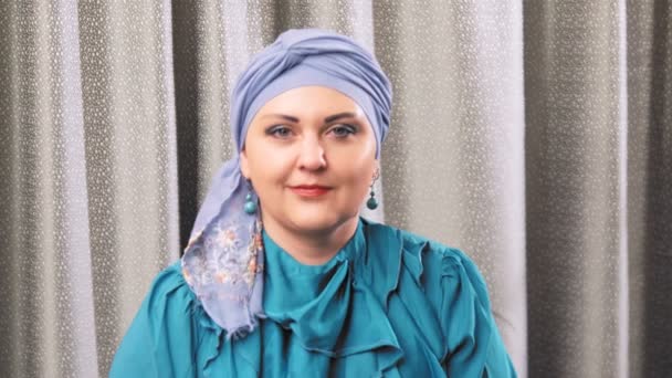 Еврейская женщина в традиционном головном уборе смотрит в камеру с улыбкой — стоковое видео