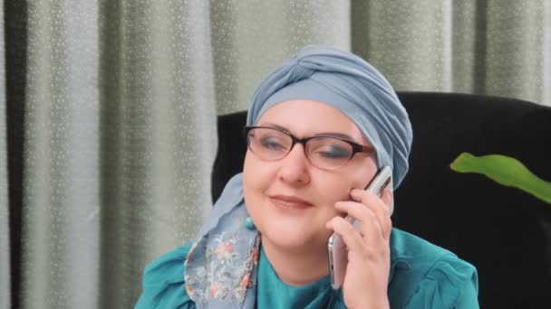 Jewish woman in a headdress and glasses works in a home office — Stock Video