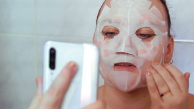Yüzünde bez maske olan bir kadın selfie çeker..