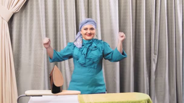Yahudi bir kadın odadaki ütü masasında dans ediyor. — Stok video