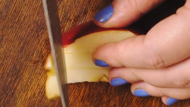 Bir kadının eli, tahta bir tahtanın üzerinde bıçakla elmaları küp küp keser.. — Stok video