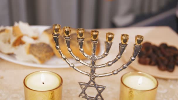 Jewish hands take pieces of challah from the dish at the Shabbat meal — Stock Video