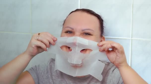 Woman Puts Sheet Mask Her Face Medium Plan — Stock Video