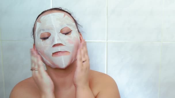顔に布のマスクをした女性が手で顔を通している 中期計画 — ストック動画