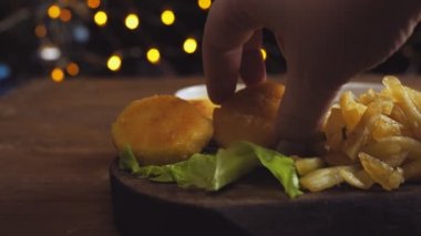 Eller kalastan külçeleri alır ve sosa batırır. Ortam planı