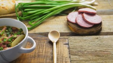 Yahudi mutfağı fasulye çorbası. Kaşıklı ekmek ve kosher sosis.