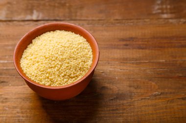 Kuskus ahşap bir masada kilden bir tabakta inliyor..