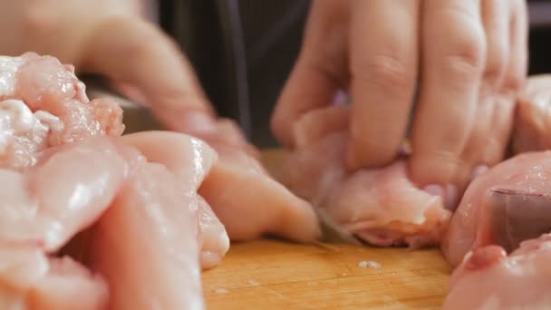 Женская рука режет курицу на доске ножом. — стоковое видео