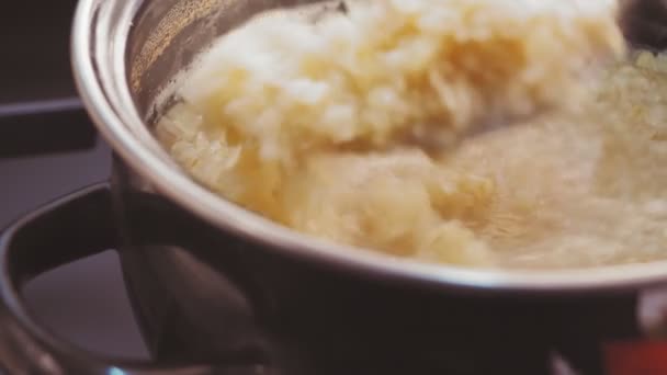 Bulgur wordt gekookt in een pan en gemengd met een lepel — Stockvideo