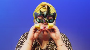 Başlıklı ve karnaval maskeli Yahudi bir kadın Purim 'deki sinagogda gürültü yapmayı emrediyor.