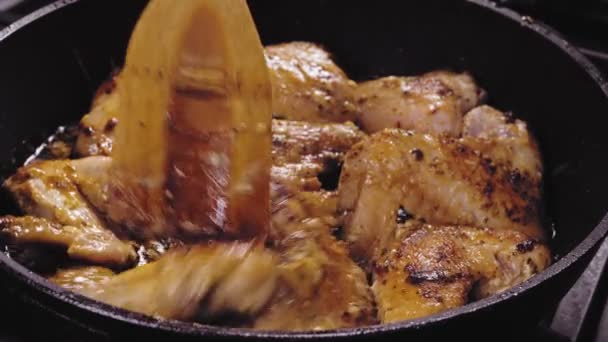 Kippenvleugels worden gebakken in saus en specerijen en omgedraaid met een spatel — Stockvideo