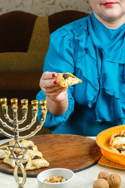 一名犹太妇女将普林节前新鲜烘焙的哥门达什传统移交给了董事会 垂直照片 — 图库照片