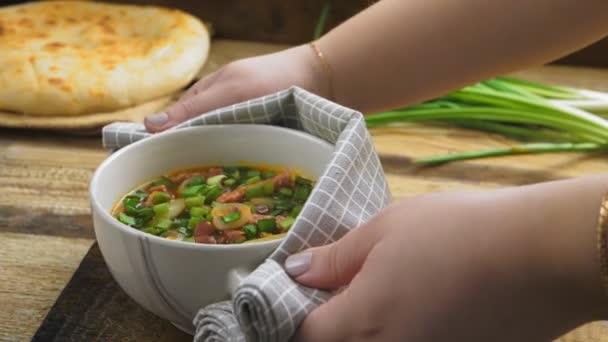Las manos de las mujeres ponen sobre la mesa una sopa tureen con sopa de frijol chelit de cocina judía con huesos — Vídeos de Stock