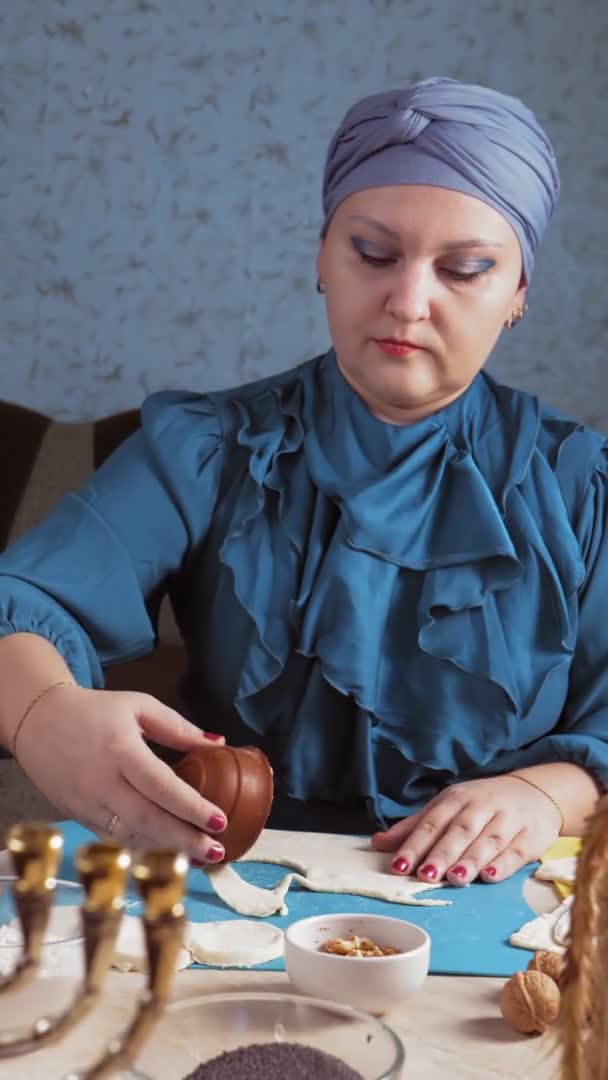 Una donna ebrea con un copricapo fa biscotti gomentashi per Purim — Video Stock