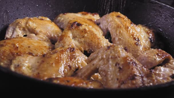 盐和胡椒撒在鸡翅上，用沸腾的油在低温下煎 — 图库视频影像