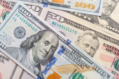 Ardarda yüz dolarlık banknotlar düz bir şekilde serilmiş ve yayılmış..