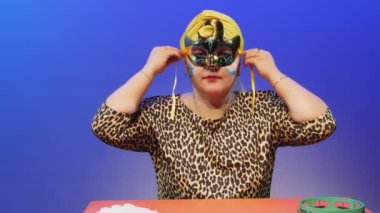 Başlık takmış boyalı Magendovid suratlı Yahudi bir kadın Purim 'de karnaval maskesi takıyor.