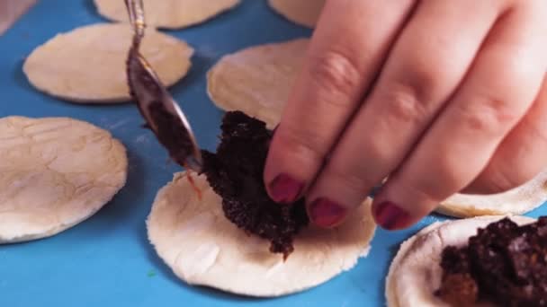 Kvinnors händer skulpterar gomentashi cookies för Purim semester med vallmofrön — Stockvideo