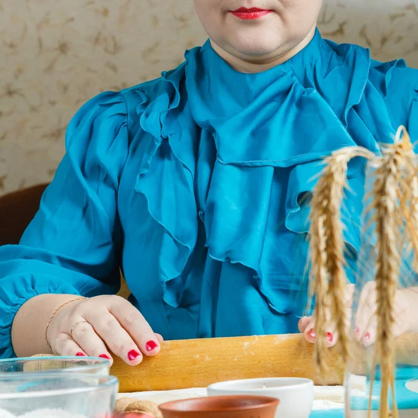 女人的手伸出面团.加有罂粟籽的Gomentash饼干，是犹太节日Purim的传统饼干，放在圣餐桌上. — 图库照片