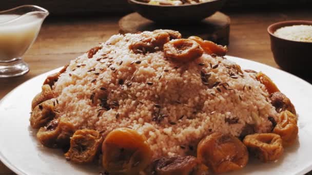 Ο λιναρόσπορος χύνεται σε ένα πιάτο με κους κους με αποξηραμένα φρούτα και ξηρούς καρπούς — Αρχείο Βίντεο
