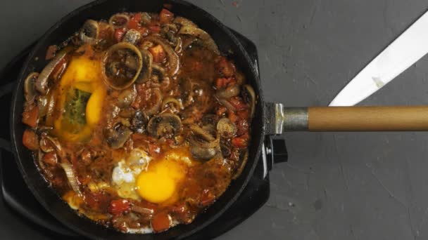 Shakshuka met eieren wordt op laag vuur gebakken in een koekenpan — Stockvideo
