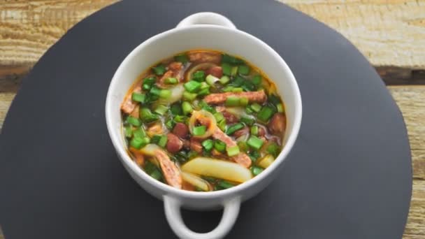 Cocina judía frijol sopa cholit bean con tomate y carnes ahumadas en la mesa cuchara de pan y salchicha kosher — Vídeo de stock