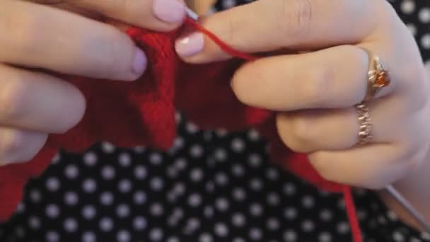 Kvinnors händer stickar på stickor av rött garn — Stockvideo