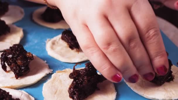 Las manos de las mujeres están esculpiendo galletas gomentashi para las vacaciones de Purim con semillas de amapola. — Vídeo de stock