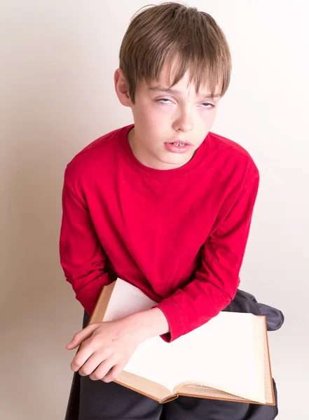 Verveeld jongen lezen van een boek — Stockfoto