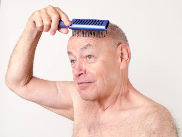 Un hombre calvo usando un cepillo de pelo — Foto de Stock