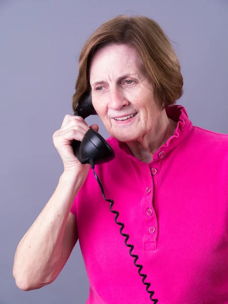 Mujer mayor escuchando el teléfono — Foto de Stock