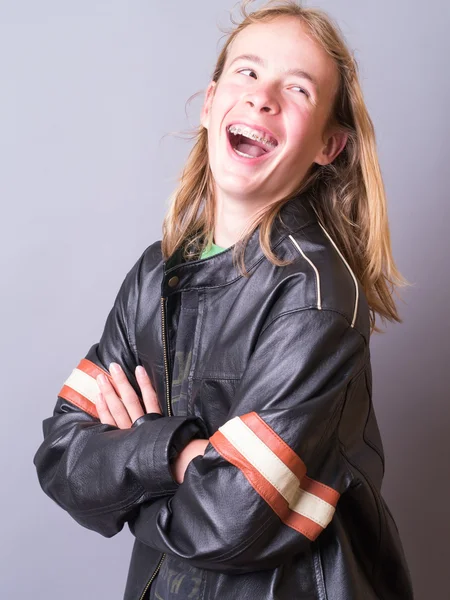 Adolescente feliz en chaqueta de cuero negro y frenos riendo — Foto de Stock