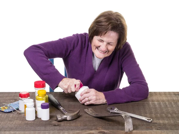 Äldre kvinna kämpar för att öppna hennes medicin flaska — Stockfoto