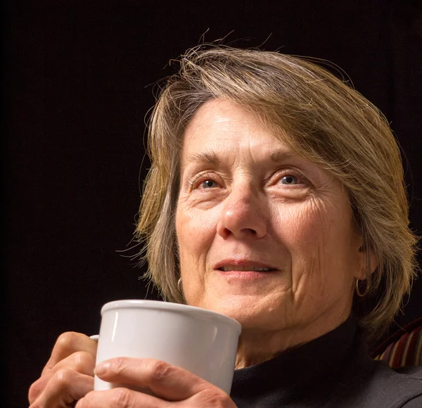 Äldre kvinna med kopp kaffe eller te — Stockfoto