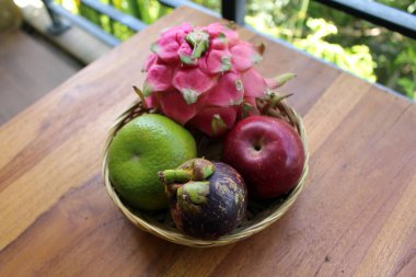 Bir kase Endonezya tropik meyvesi. Ejderha meyvesi, mangosteen, elma, portakal.