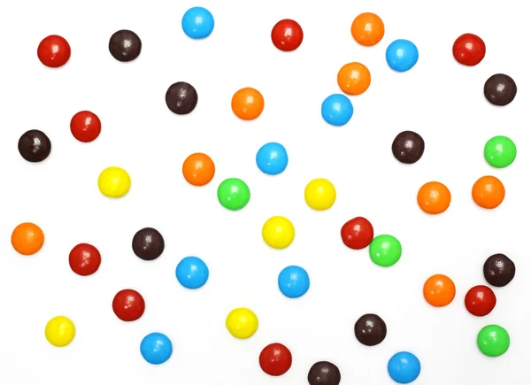 Lots of colorful candies spread on white background — Stock Photo, Image